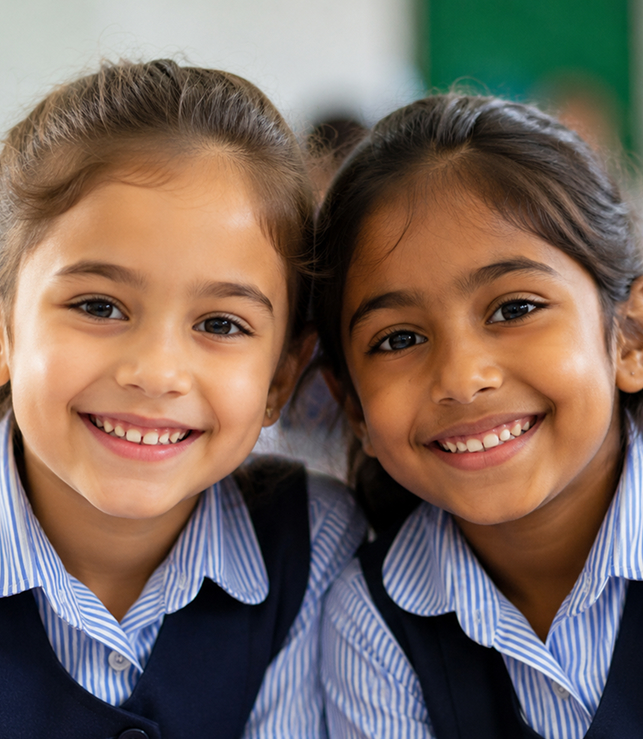 Two smiling students in school uniform
