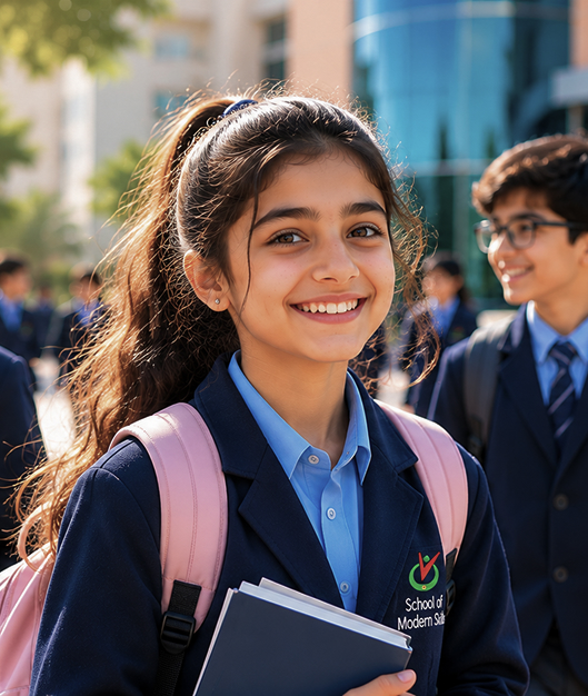Girls Division student smiling outdoors with books