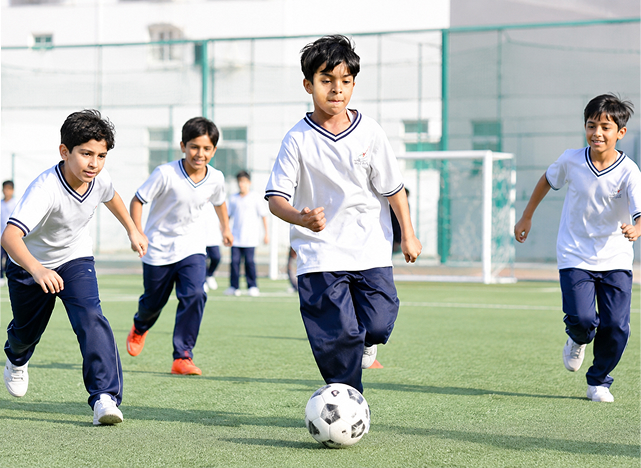 Students playing football in the school outdoor sports area